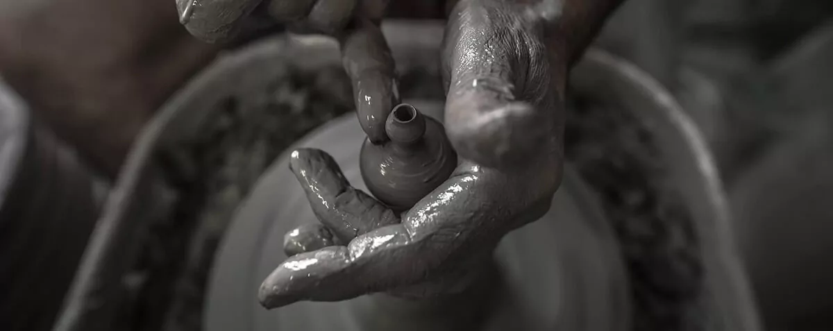 The hands of a master potter of Cutrofiano at the wheel, shaping a small clay vase