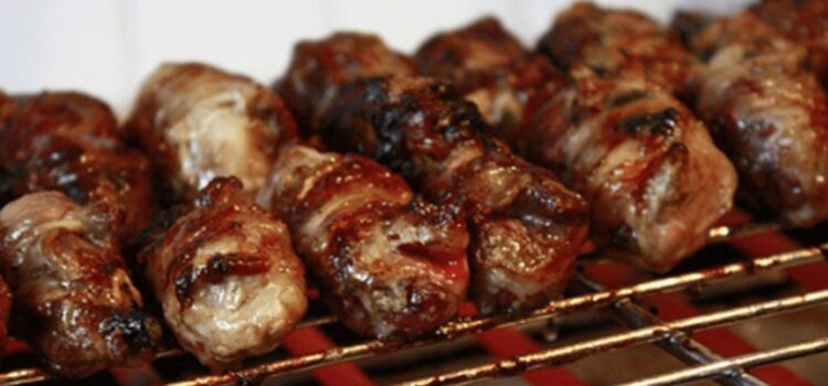 Gnummareddi, small rolls of lamb offal, grilling over coals
