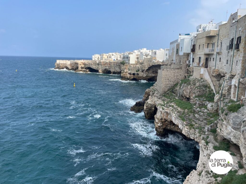 The limestone cliffs of Polignano a Mare with the white houses of the old town built right on the edge