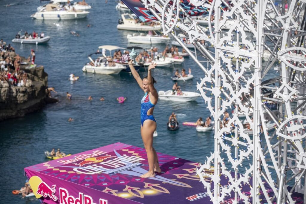 Italy’s Elisa Cosetti salutes the crowd from the Red Bull Cliff Diving platform at Polignano, with boats and rocks full of spectators below