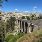 The aqueduct bridge of Gravina in Puglia over the ravine, with the old town and the rock churches behind