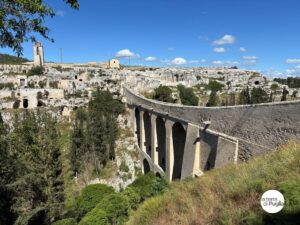 The aqueduct bridge of Gravina in Puglia over the ravine, with the old town and the rock churches behind