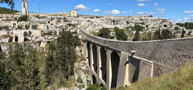 The aqueduct bridge of Gravina in Puglia over the ravine, with the old town and the rock churches behind