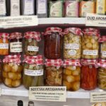 A shelf of Apulian artisan preserves: vegetables in oil, olives and extra virgin olive oil