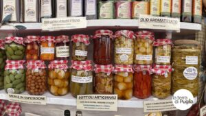 A shelf of Apulian artisan preserves: vegetables in oil, olives and extra virgin olive oil