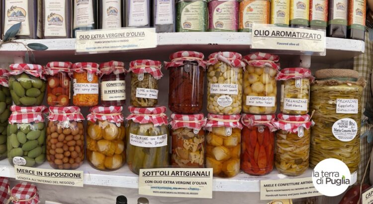 A shelf of Apulian artisan preserves: vegetables in oil, olives and extra virgin olive oil